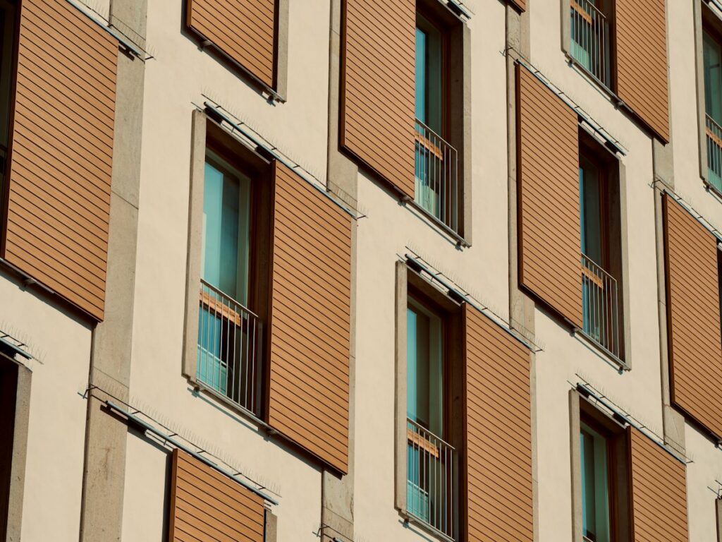 Facciata di un edificio residenziale in città con schermature esterne scorrevoli a listelli davanti alle finestre